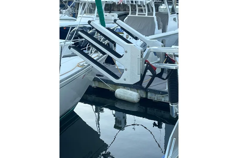 Slide: The Image of 2021 MasterCraft XT21 boat docked with wakeboard rack visible. - 18