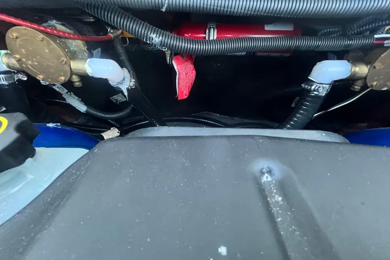 Slide: The Image of Engine compartment of a 2021 MasterCraft XT21 boat, showing hoses and components. - 34