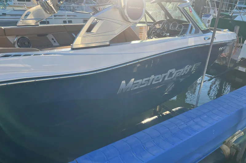 Slide: The Image of 2021 MasterCraft XT21 boat docked, showcasing sleek design and modern features. - 4