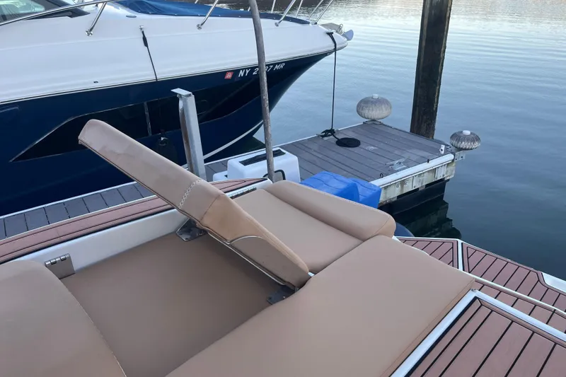 Slide: The Image of 2021 MasterCraft XT21 boat with tan seating, docked beside a pier. - 9