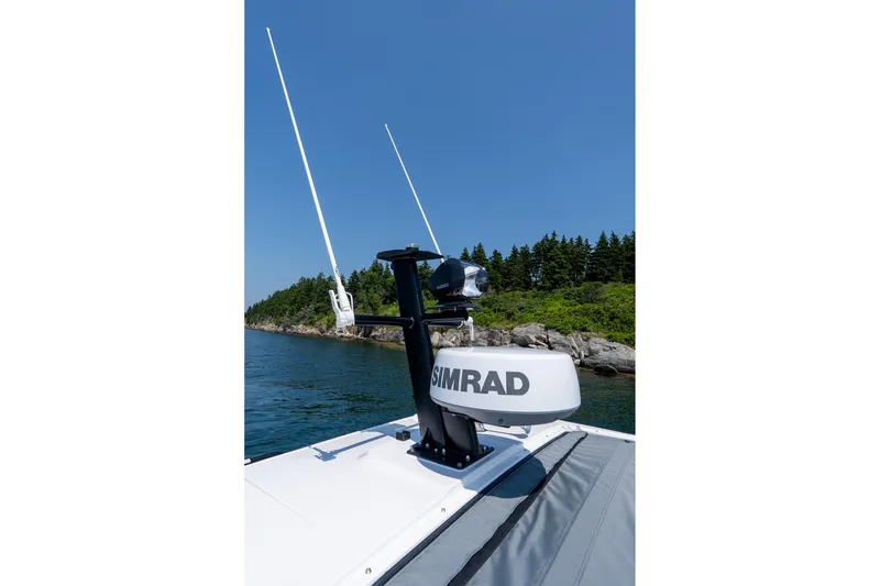 Slide: The Image of 2026 Axopar 37 Aft Cabin with Simrad radar, cruising near rocky shoreline. - 27