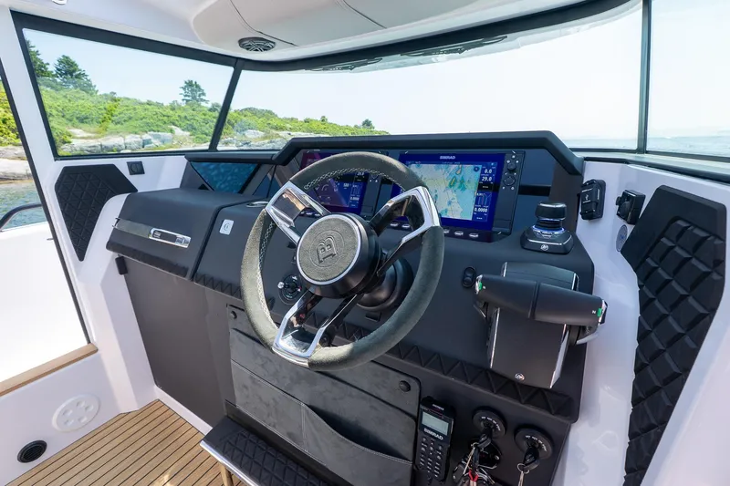 Slide: The Image of 2026 Axopar 37 Aft Cabin helm with modern navigation system and sleek steering wheel. - 37