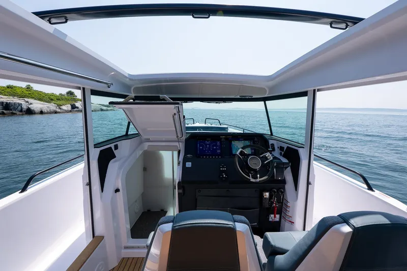 Slide: The Image of Interior view of 2026 Axopar 37 Aft Cabin boat, featuring modern helm and ocean backdrop. - 43