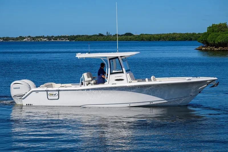 Slide: The Image of 2024 Sea Hunt Ultra 305 SE boat cruising on calm blue waters. - 0