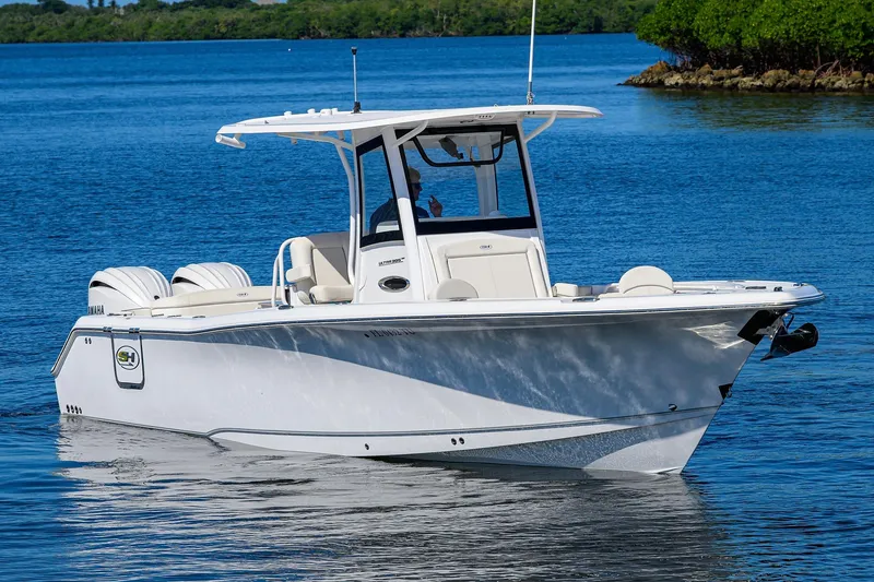 Slide: The Image of 2024 Sea Hunt Ultra 305 SE boat on calm blue water. - 1