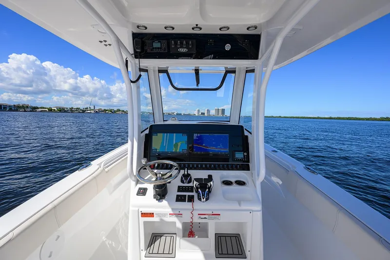 Slide: The Image of 2024 Sea Hunt Ultra 305 SE boat helm with navigation system on open water. - 11