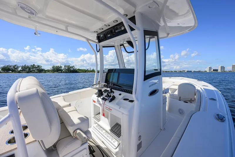 Slide: The Image of 2024 Sea Hunt Ultra 305 SE boat interior with helm, on a sunny day. - 12
