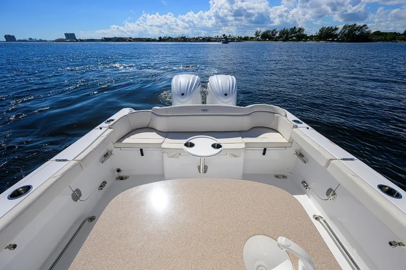 Slide: The Image of 2024 Sea Hunt Ultra 305 SE boat on calm water, featuring spacious seating and dual engines. - 24