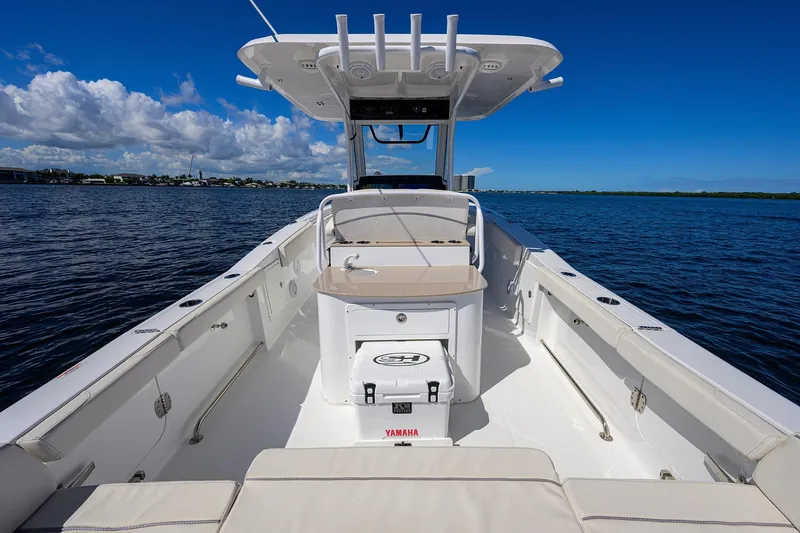 Slide: The Image of 2024 Sea Hunt Ultra 305 SE boat on calm water under clear blue sky. - 30