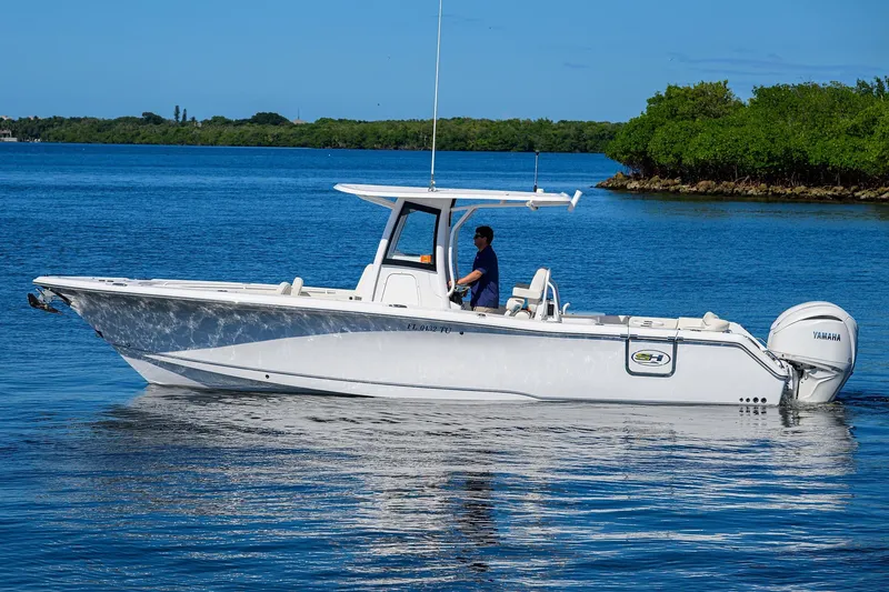 Slide: The Image of 2024 Sea Hunt Ultra 305 SE boat cruising on calm blue waters. - 4