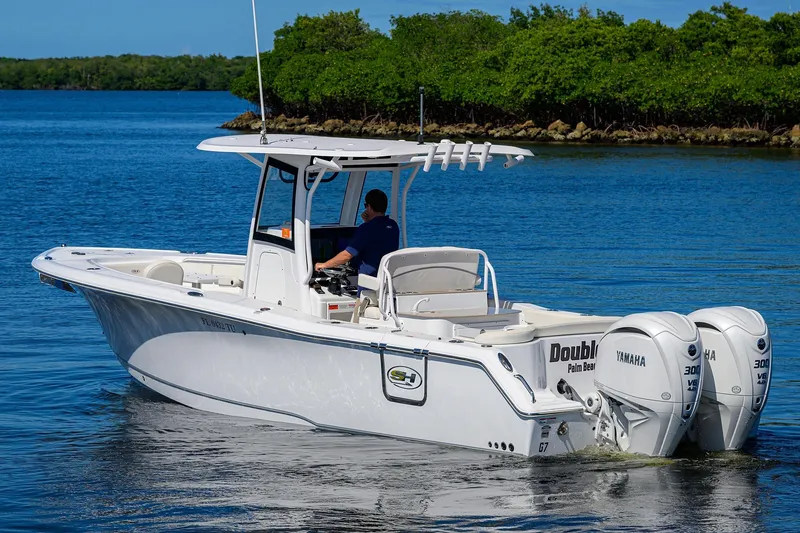 Slide: The Image of 2024 Sea Hunt Ultra 305 SE boat cruising on a serene blue lake. - 5