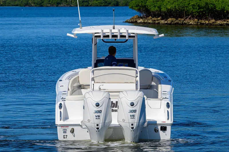 Slide: The Image of 2024 Sea Hunt Ultra 305 SE boat with dual engines on calm water. - 6