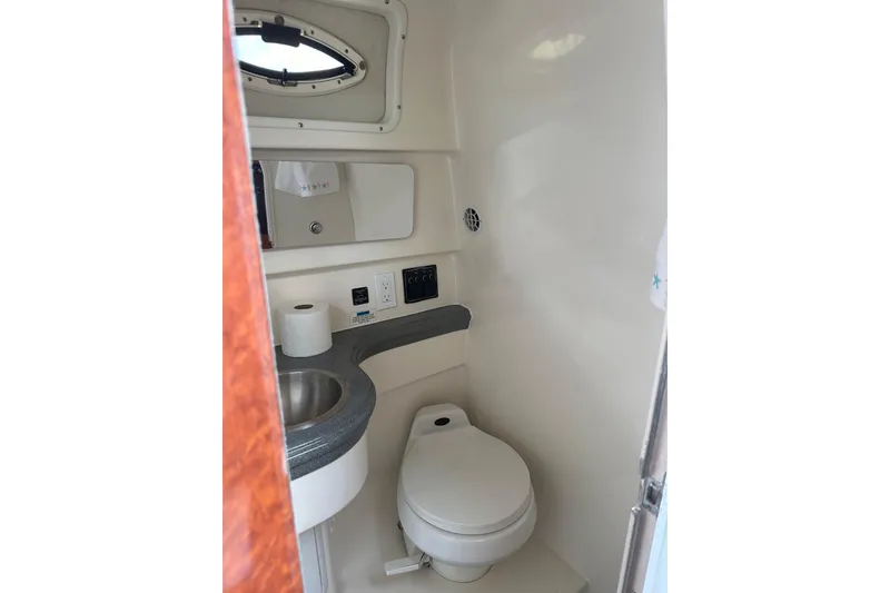 Slide: The Image of 2002 Wellcraft 2600 Martinique boat bathroom with sink, toilet, and mirror. - 13
