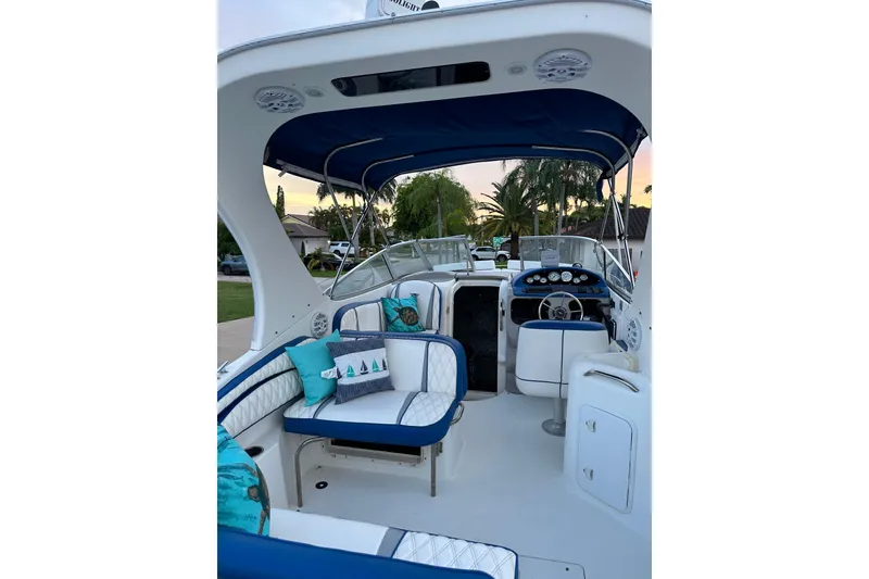 Slide: The Image of 2002 Wellcraft 2600 Martinique boat interior with blue and white seating, steering wheel, and canopy. - 6
