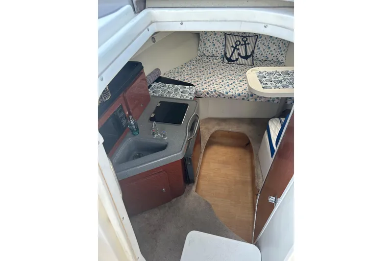 Slide: The Image of 2002 Wellcraft 2600 Martinique cabin interior with kitchenette and cozy sleeping area. - 7
