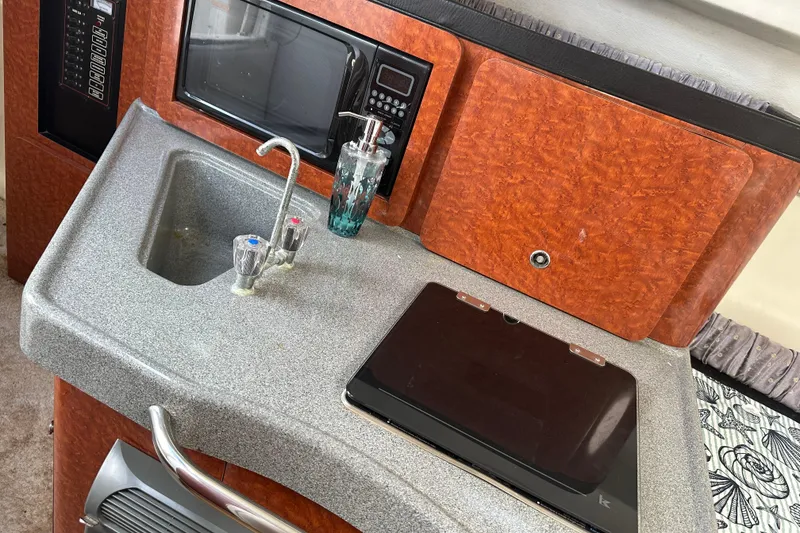 Slide: The Image of 2002 Wellcraft 2600 Martinique boat interior with sink, microwave, and countertop. - 9