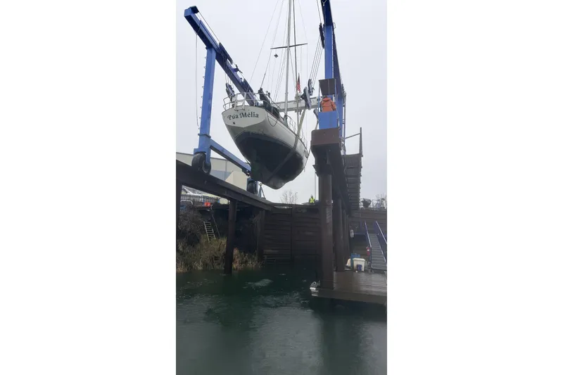 Slide: The Image of 1982 Cape Dory 33 sailboat being lifted by a crane at a dock. - 14