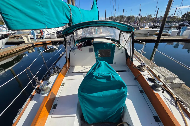 Slide: The Image of 1982 Cape Dory 33 sailboat with teal covers docked at a marina. - 5