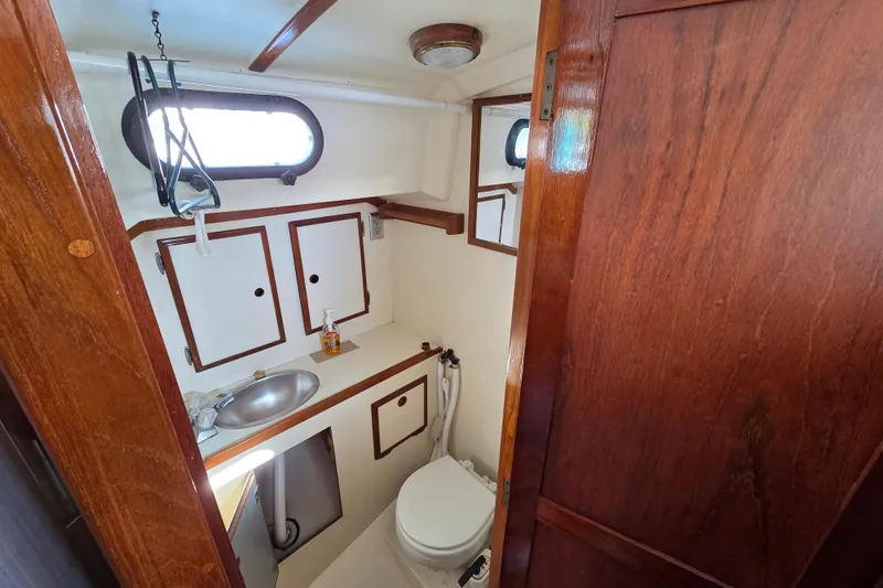 Slide: The Image of 1982 Cape Dory 33 yacht bathroom with wooden cabinetry and stainless steel sink. - 9