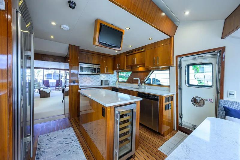 Slide: The Image of Luxurious 2009 Hatteras Enclosed Bridge yacht kitchen with modern appliances and elegant wood finishes. - 10