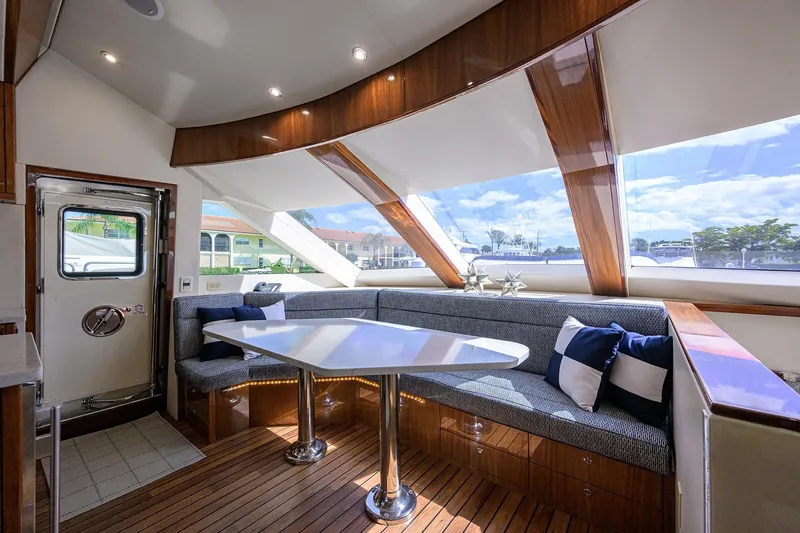 Slide: The Image of Luxurious interior of 2009 Hatteras Enclosed Bridge yacht with elegant seating and panoramic windows. - 13