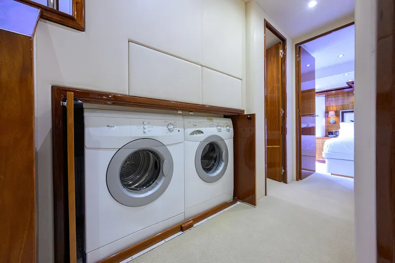 Slide: The Image of Laundry area inside 2009 Hatteras Enclosed Bridge yacht, featuring built-in washer and dryer. - 15