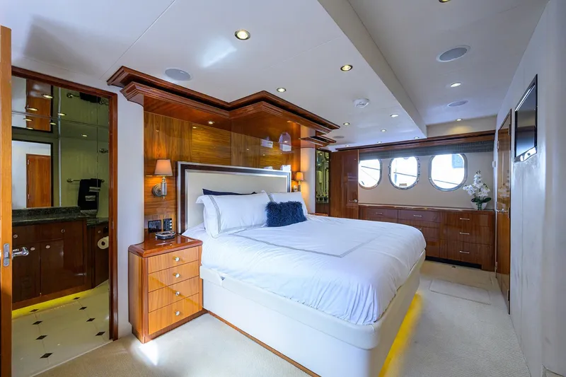 Slide: The Image of Luxurious bedroom interior on 2009 Hatteras Enclosed Bridge yacht, featuring elegant wood finishes. - 16