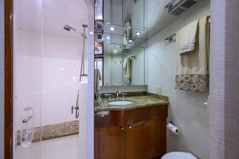 Slide: The Image of Luxurious bathroom in 2009 Hatteras Enclosed Bridge yacht with marble countertop and glass shower. - 25