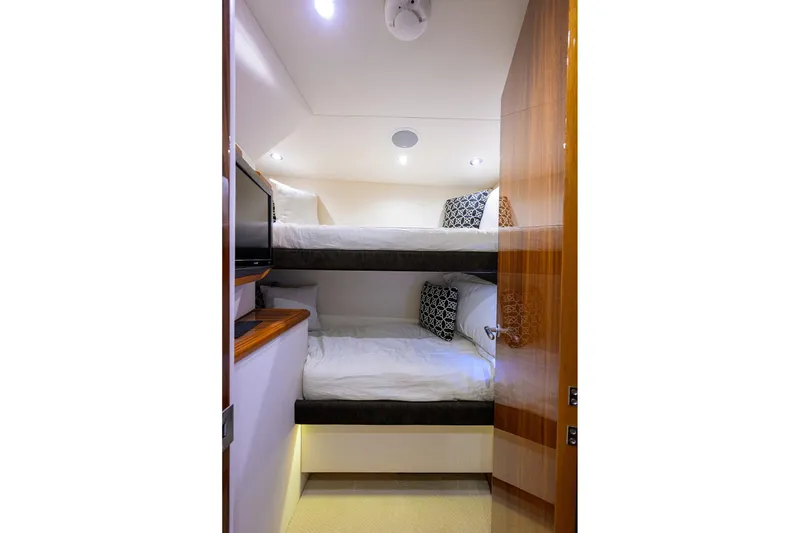 Slide: The Image of 2009 Hatteras Enclosed Bridge yacht cabin with bunk beds and modern decor. - 30