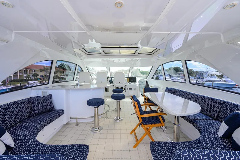 Slide: The Image of Luxurious 2009 Hatteras Enclosed Bridge yacht interior with elegant seating and panoramic windows. - 31