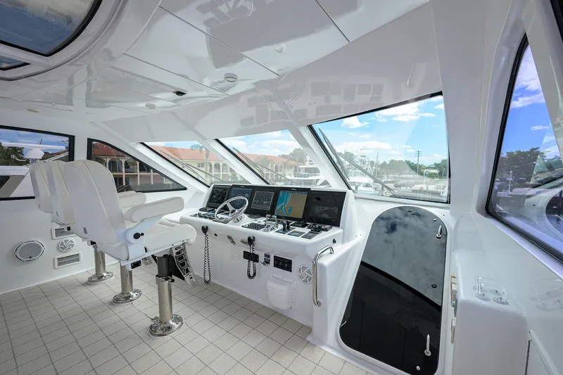 Slide: The Image of 2009 Hatteras Enclosed Bridge yacht helm with modern navigation equipment and panoramic windows. - 34