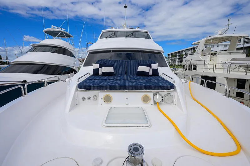 Slide: The Image of 2009 Hatteras Enclosed Bridge yacht with blue cushions, docked under a clear sky. - 43