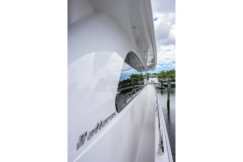 Slide: The Image of Side view of a 2009 Hatteras Enclosed Bridge yacht docked by the water. - 44
