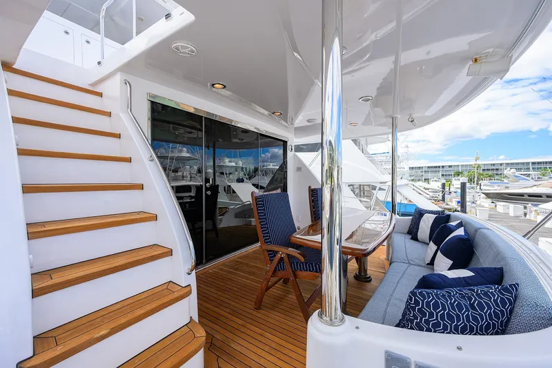 Slide: The Image of Luxurious 2009 Hatteras Enclosed Bridge yacht deck with seating, table, and staircase. - 45