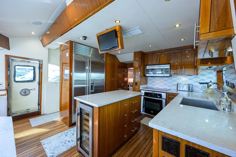 Slide: The Image of Luxurious 2009 Hatteras Enclosed Bridge yacht kitchen with modern appliances and elegant wood finishes. - 9
