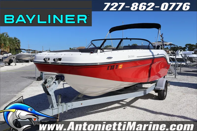 Slide: The Image of 2023 Bayliner DX 2000 boat in red and white on a trailer at Antonietti Marine. - 1