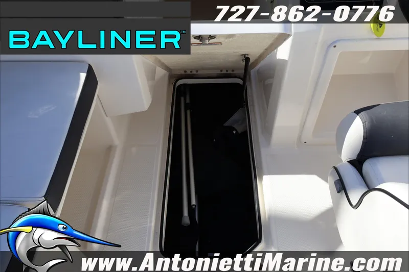 Slide: The Image of 2023 Bayliner DX 2000 boat interior storage compartment, featuring seating and marine branding. - 32