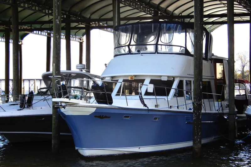 The Image of 1989 Jefferson 46 Sundeck yacht docked under covered marina. - 0