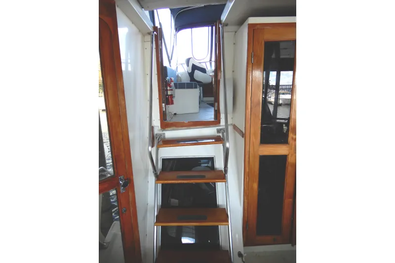 Slide: The Image of Interior stairs of 1989 Jefferson 46 Sundeck yacht with wooden accents. - 13