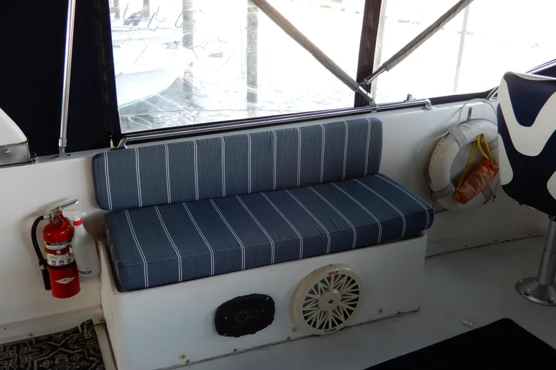 Slide: The Image of 1989 Jefferson 46 Sundeck interior with striped seating, fire extinguisher, and life preserver. - 17