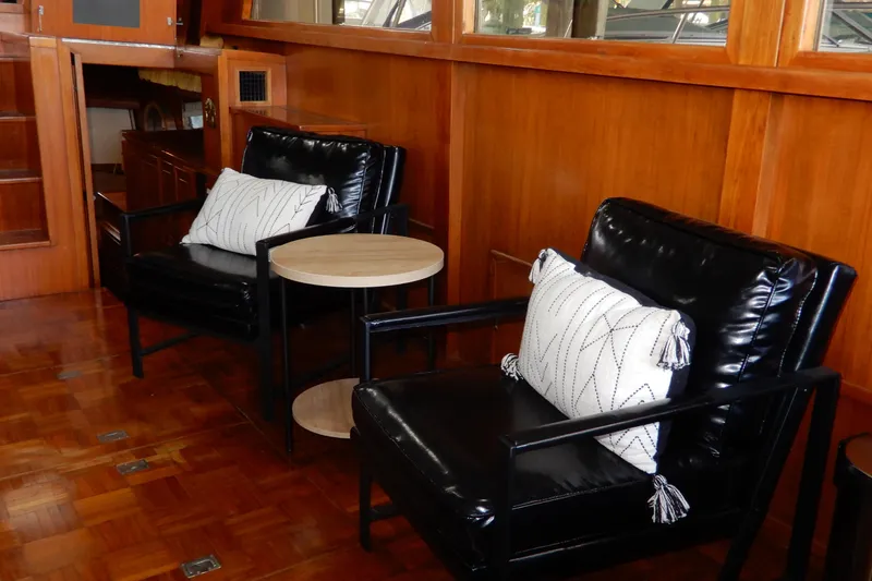 Slide: The Image of Interior of 1989 Jefferson 46 Sundeck yacht with black chairs and wooden paneling. - 31