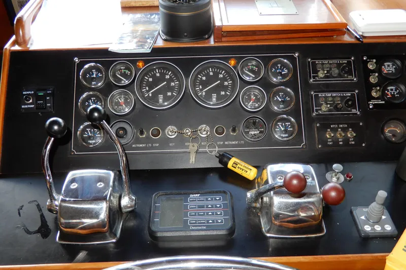 Slide: The Image of Control panel of a 1989 Jefferson 46 Sundeck boat with gauges and levers. - 33