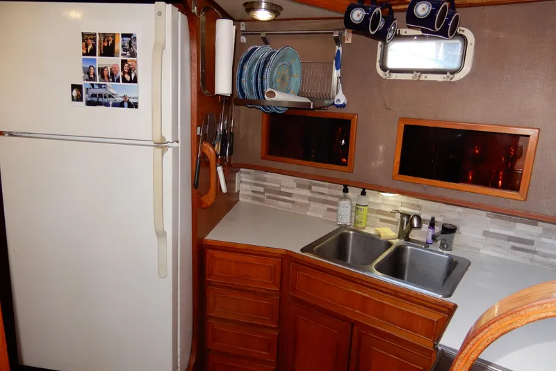 Slide: The Image of 1989 Jefferson 46 Sundeck kitchen with fridge, sink, and wooden cabinets. - 36