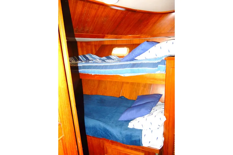 Slide: The Image of 1989 Jefferson 46 Sundeck interior with wooden bunk beds and blue bedding. - 42