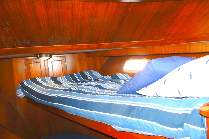 Slide: The Image of Cozy cabin interior of 1989 Jefferson 46 Sundeck with striped bedding and wooden paneling. - 43