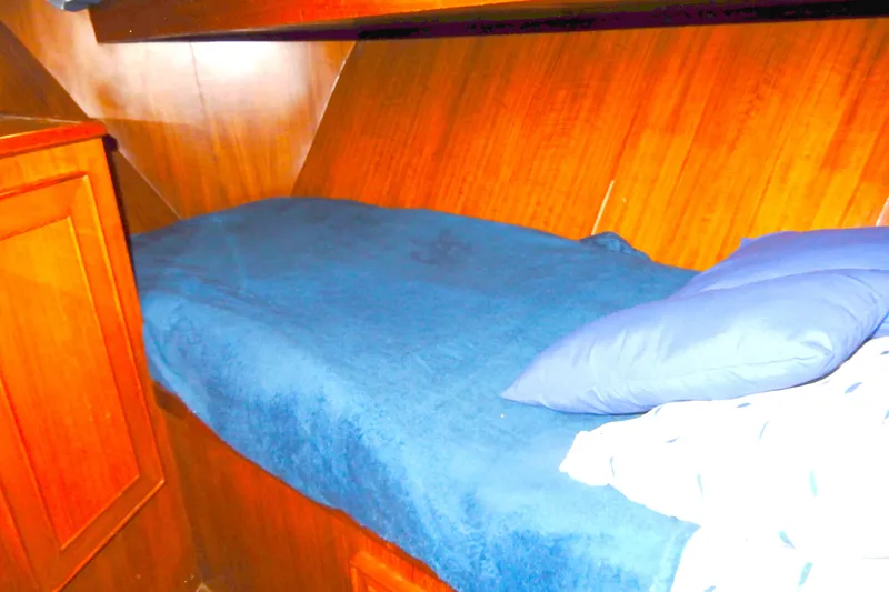 Slide: The Image of 1989 Jefferson 46 Sundeck cabin interior with wooden paneling and blue bedding. - 44