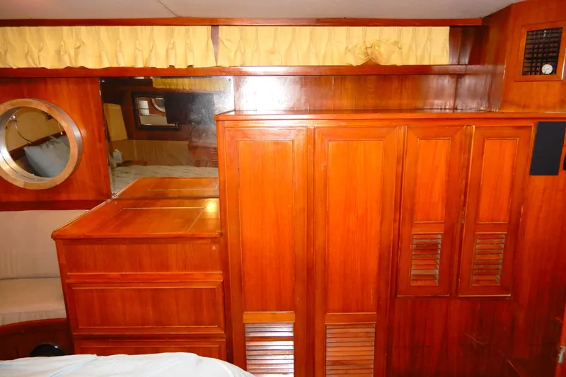 Slide: The Image of 1989 Jefferson 46 Sundeck interior with wooden cabinetry and porthole window. - 54