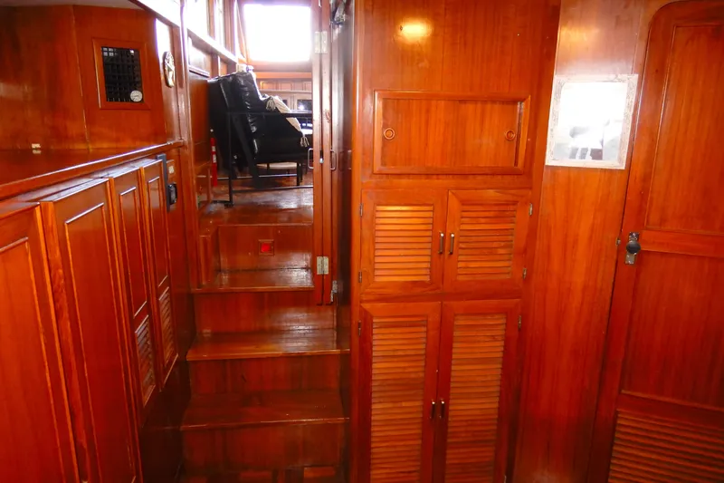 Slide: The Image of 1989 Jefferson 46 Sundeck interior with wooden cabinetry and stairs leading to seating area. - 56