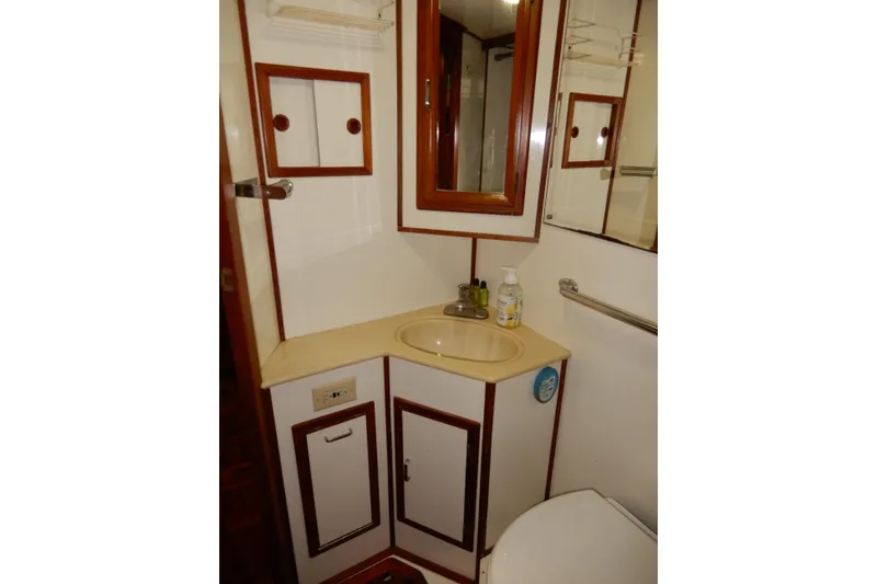 Slide: The Image of 1989 Jefferson 46 Sundeck yacht bathroom with sink, mirror, and storage cabinets. - 58