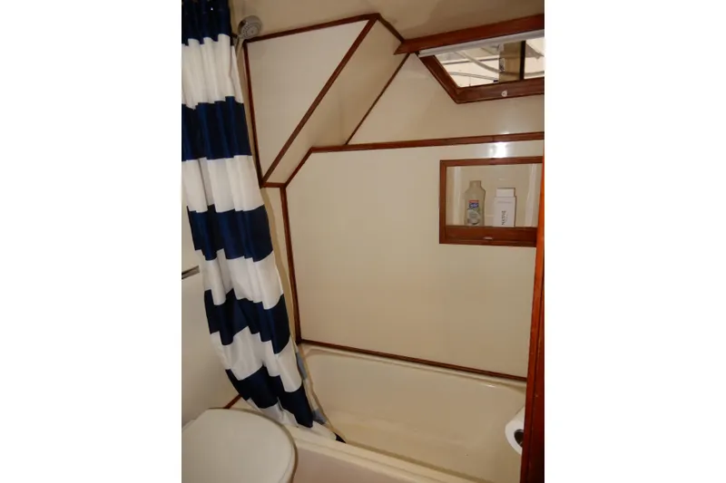 Slide: The Image of Bathroom interior of 1989 Jefferson 46 Sundeck yacht with striped shower curtain. - 59